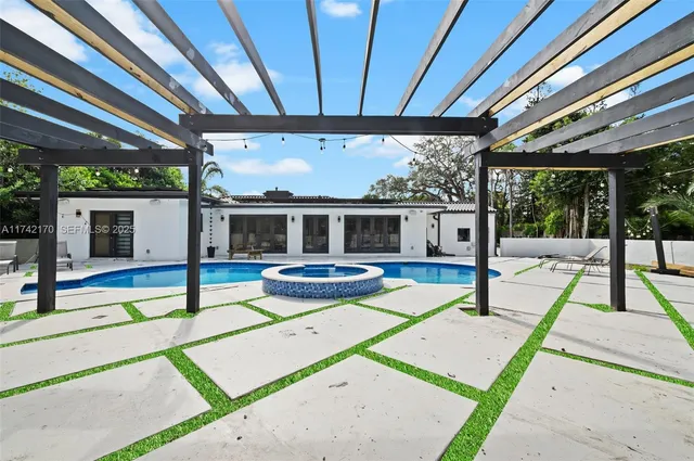 a view of a house with swimming pool and sitting area