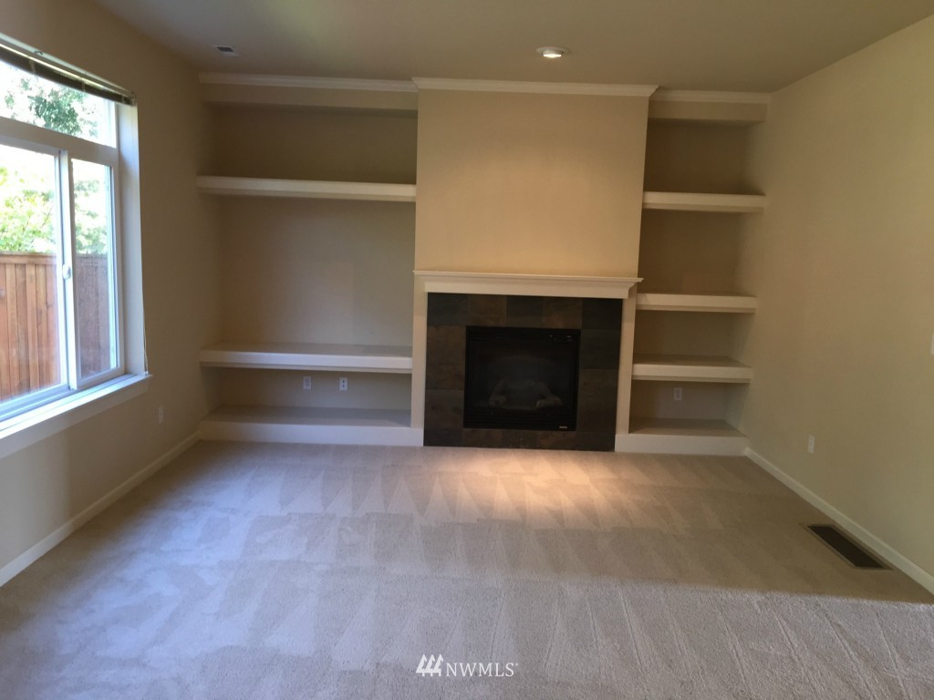 817 234th Place Southeast Bothell, WA 98021 - Photo 5 of 24 an empty room with a fireplace and a window