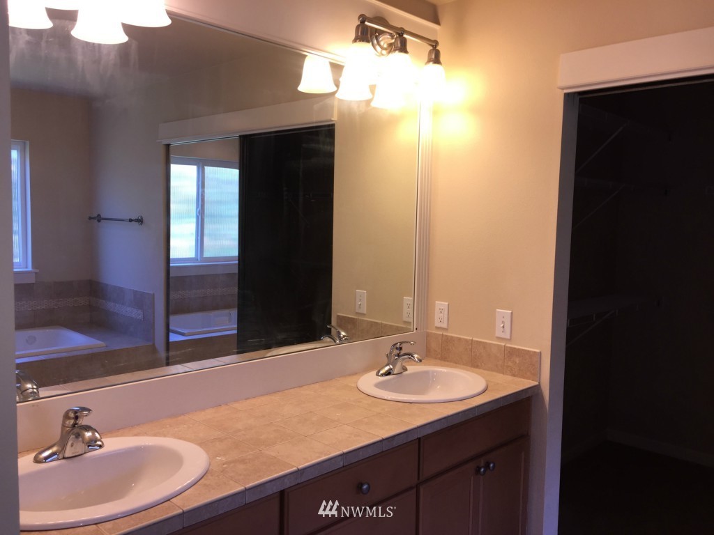 817 234th Place Southeast Bothell, WA 98021 - Photo 9 of 24 a bathroom with a granite countertop sink and a mirror