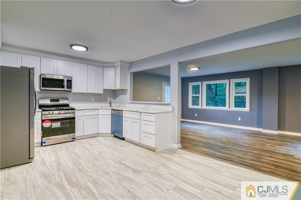 8 Halsey Road Kendall Park, NJ 08824 - Photo 14 of 30 a kitchen with stainless steel appliances a refrigerator and a stove top oven