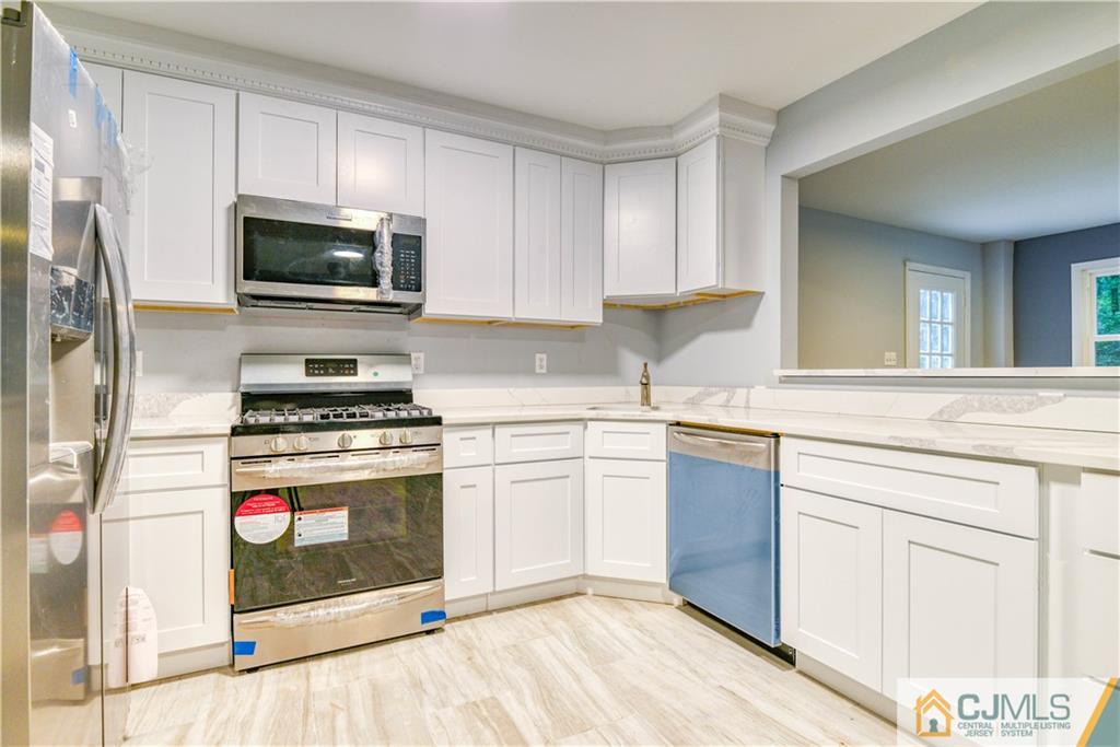8 Halsey Road Kendall Park, NJ 08824 - Photo 15 of 30 a kitchen with white cabinets stainless steel appliances and sink