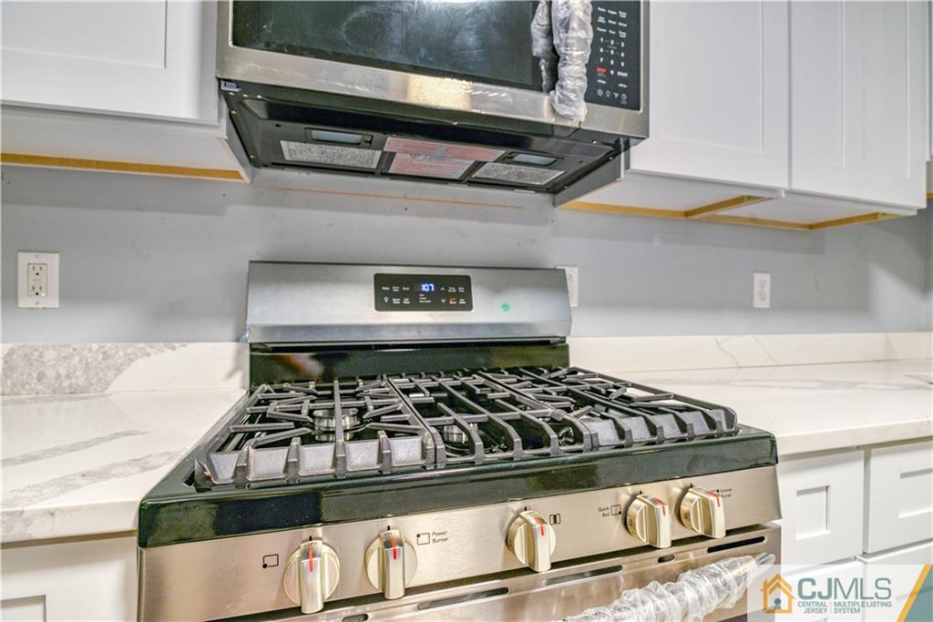 8 Halsey Road Kendall Park, NJ 08824 - Photo 16 of 30 a kitchen with a stove and a microwave