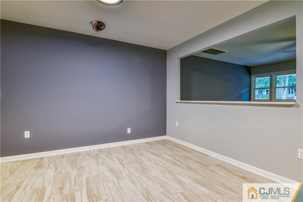 8 Halsey Road Kendall Park, NJ 08824 - Photo 18 of 30 a view of an empty room with wooden floor and a window