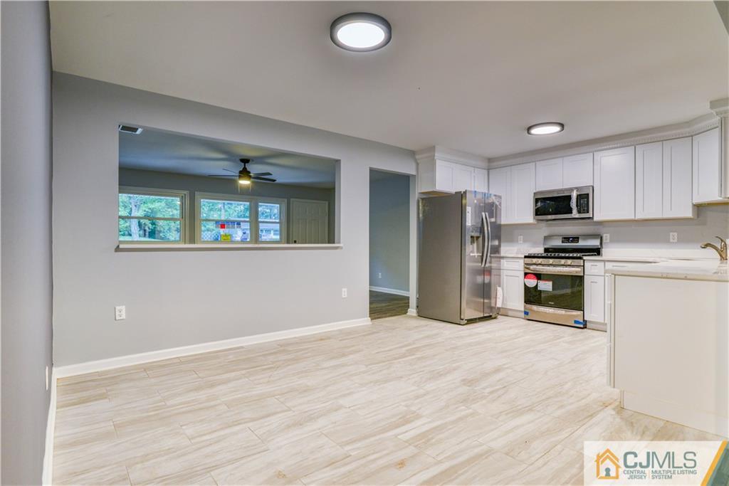 8 Halsey Road Kendall Park, NJ 08824 - Photo 19 of 30 a kitchen with granite countertop a refrigerator and a stove top oven