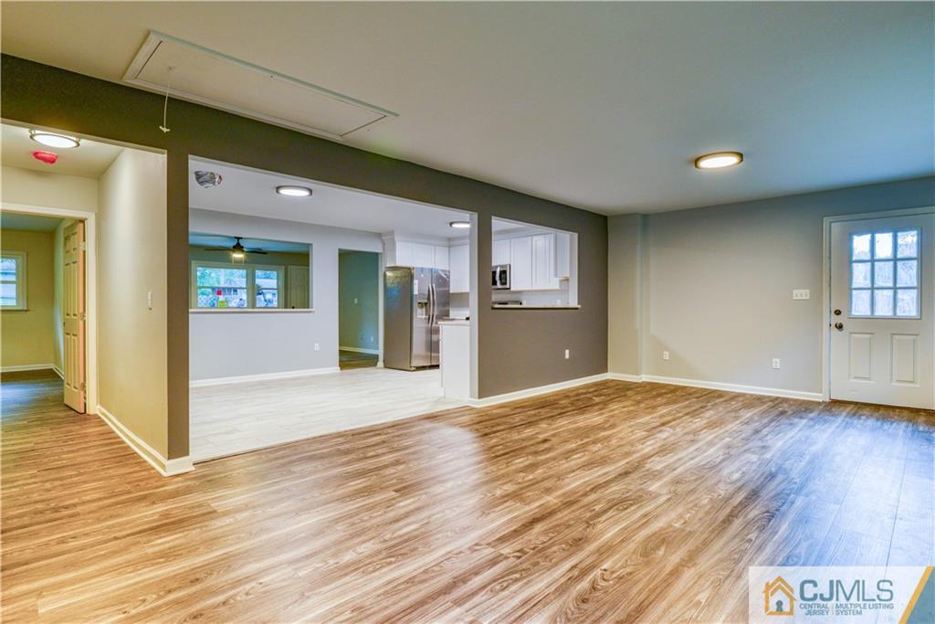 8 Halsey Road Kendall Park, NJ 08824 - Photo 22 of 30 a view of an empty room and kitchen with wooden floor