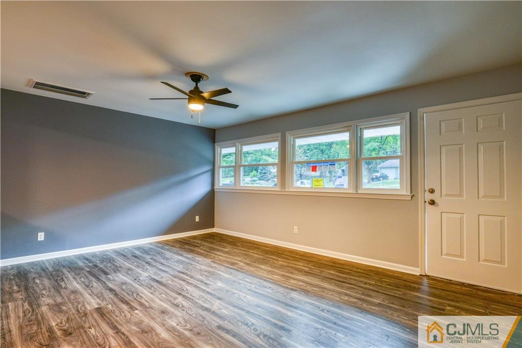 8 Halsey Road Kendall Park, NJ 08824 - Photo 5 of 30 an empty room with wooden floor and windows