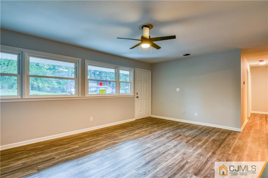 8 Halsey Road Kendall Park, NJ 08824 - Photo 6 of 30 a view of an empty room with window and wooden floor