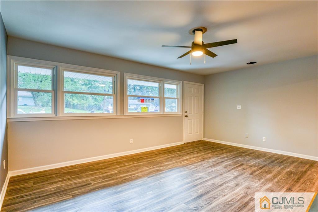 8 Halsey Road Kendall Park, NJ 08824 - Photo 7 of 30 a view of an empty room with window and wooden floor