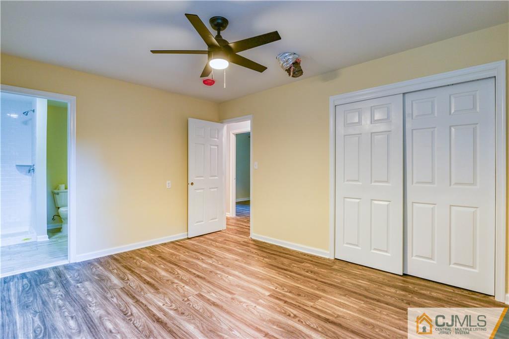 8 Halsey Road Kendall Park, NJ 08824 - Photo 9 of 30 a view of a livingroom with wooden floor and a ceiling fan