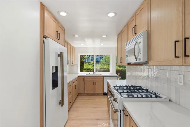 a kitchen with white cabinets and appliances