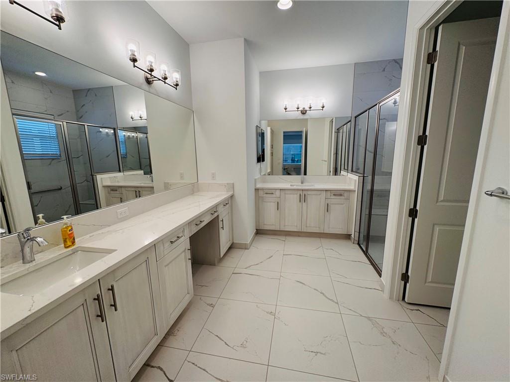 2864 Bloomfield Way Naples, FL 34112 - Photo 23 of 40 a bathroom with a double vanity sink a toilet a mirror and vanity