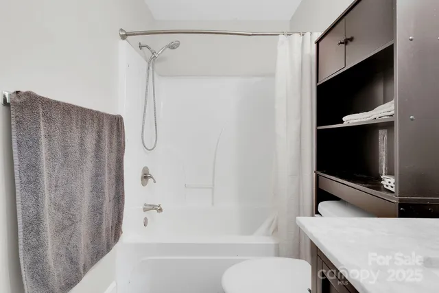a bathroom with a tub toilet and shower