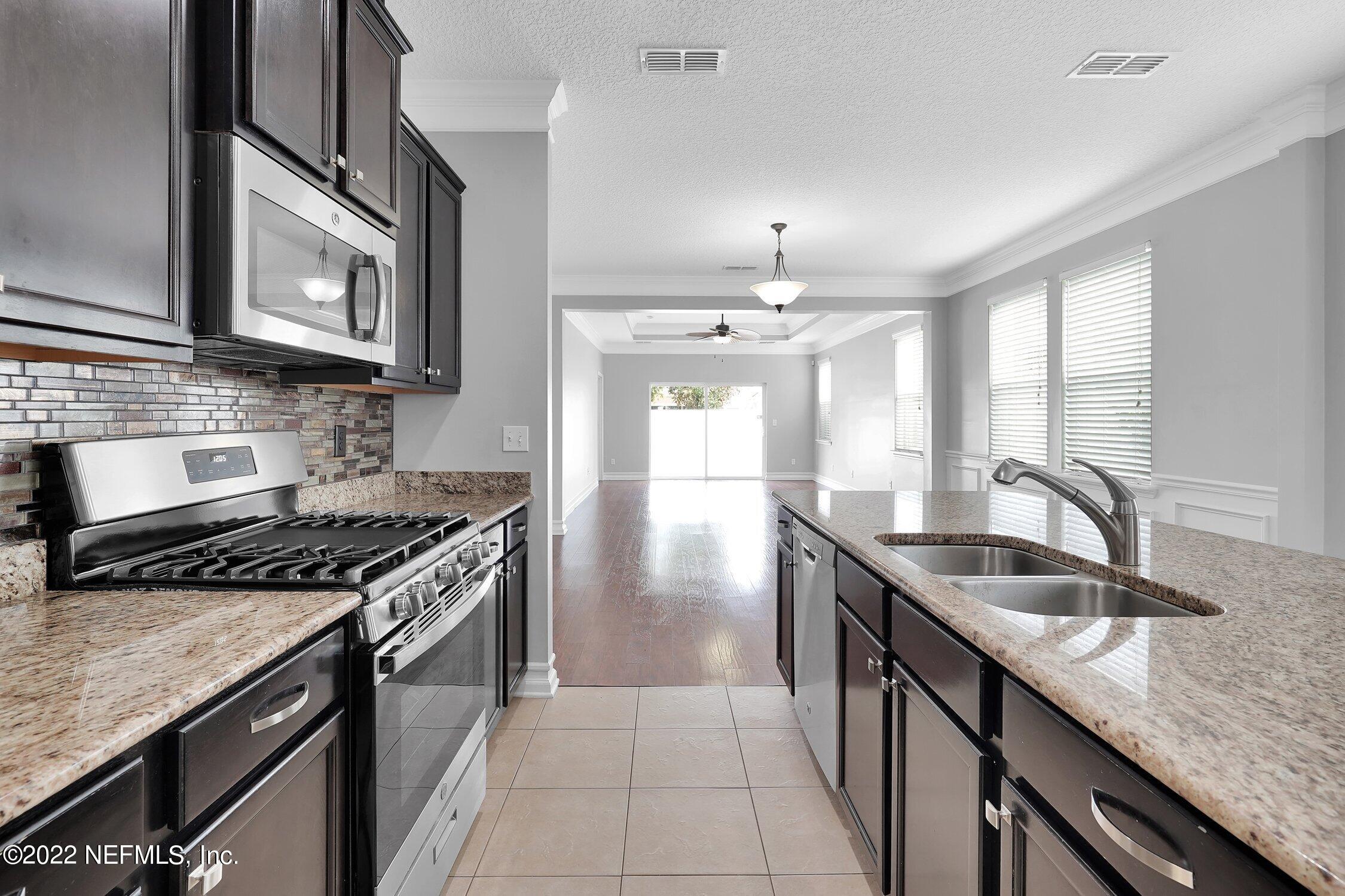 242 Taylor Ridge Avenue Ponte Vedra, FL 32081 - Photo 12 of 26 a kitchen with granite countertop stainless steel appliances a sink stove and cabinets