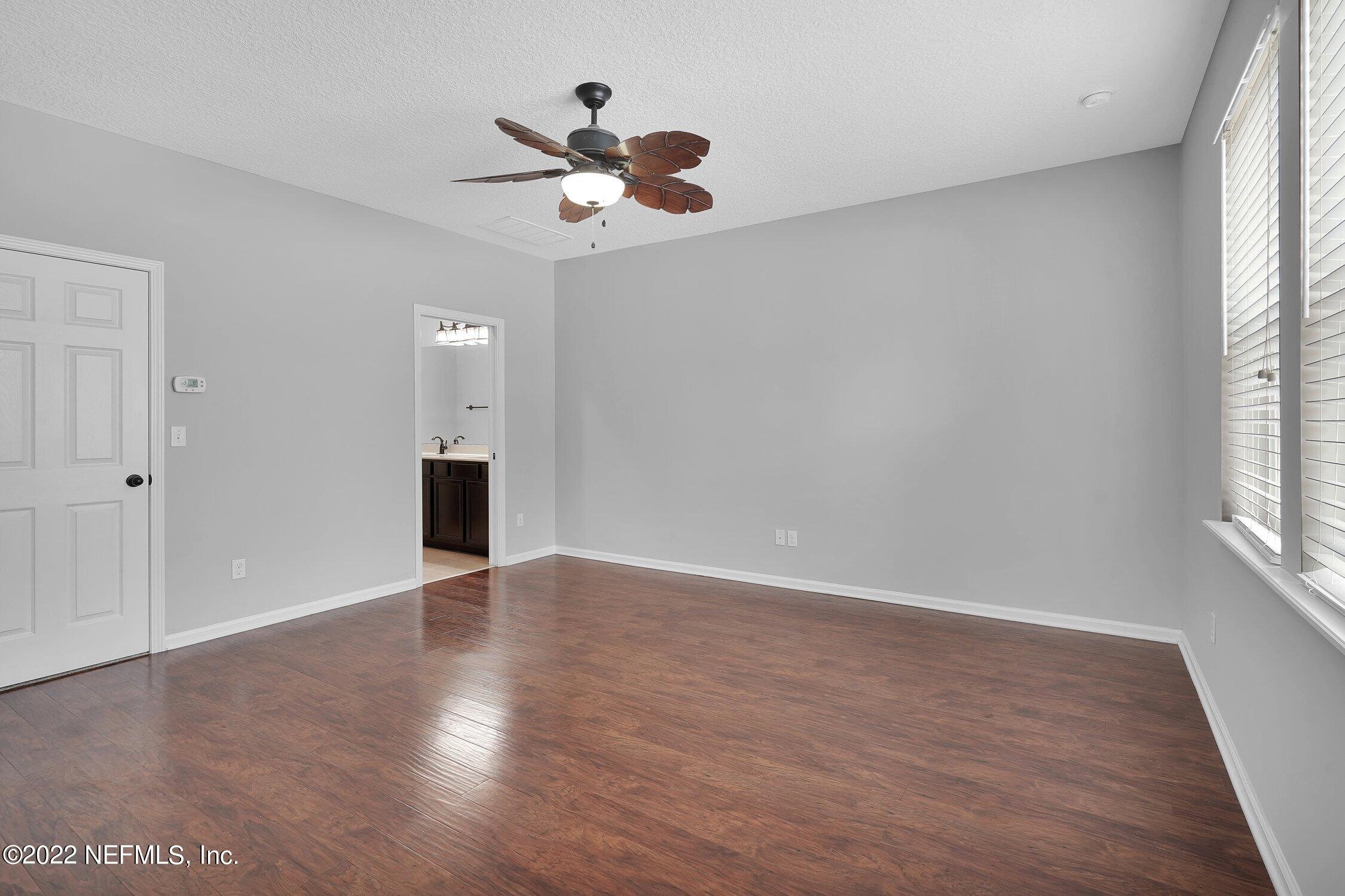 242 Taylor Ridge Avenue Ponte Vedra, FL 32081 - Photo 19 of 26 an empty room with wooden floor chandelier fan and windows