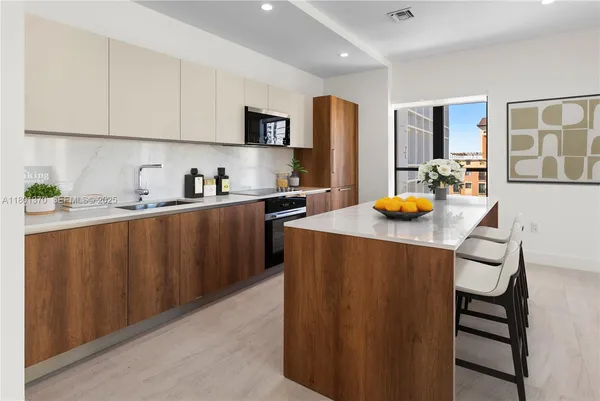 a kitchen with stainless steel appliances a sink a stove a refrigerator and cabinets