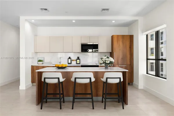 a kitchen with a table chairs refrigerator and microwave