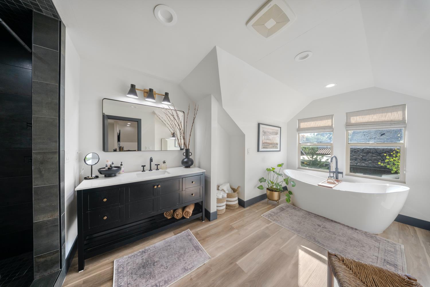 a spacious bathroom with double vanity sinks a mirror and a bathtub