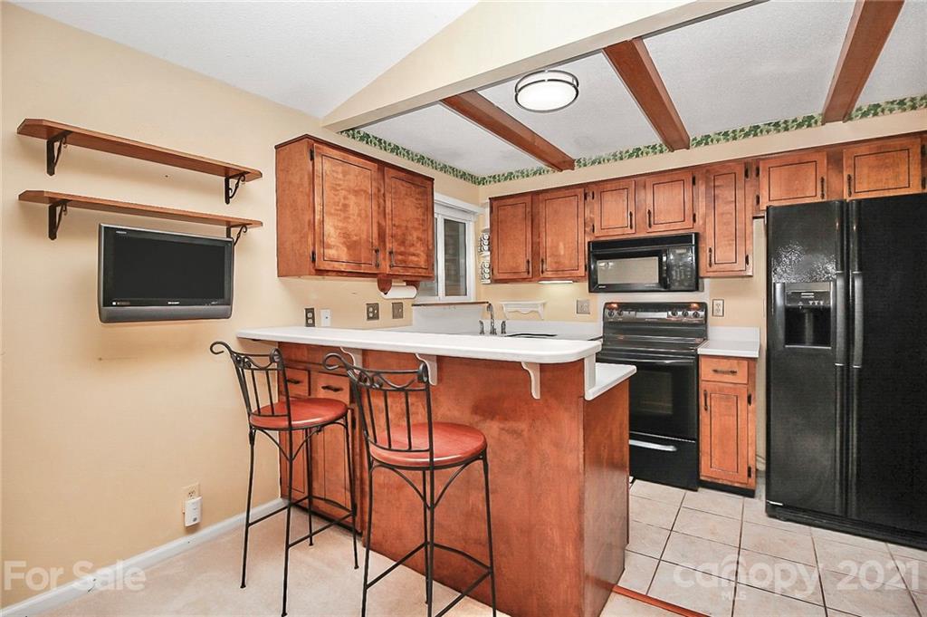 7017 Chelsea Day Lane Tega Cay, SC 29708 - Photo 12 of 48 a kitchen with stainless steel appliances kitchen island granite countertop a refrigerator and a stove top oven