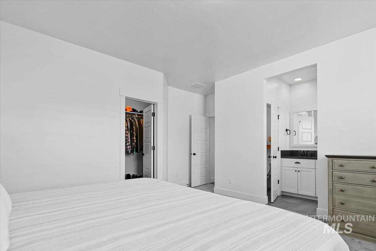 2085 North Concha Court Middleton, ID 83644 - Photo 19 of 37 Bedroom featuring a walk in closet and ensuite bathroom