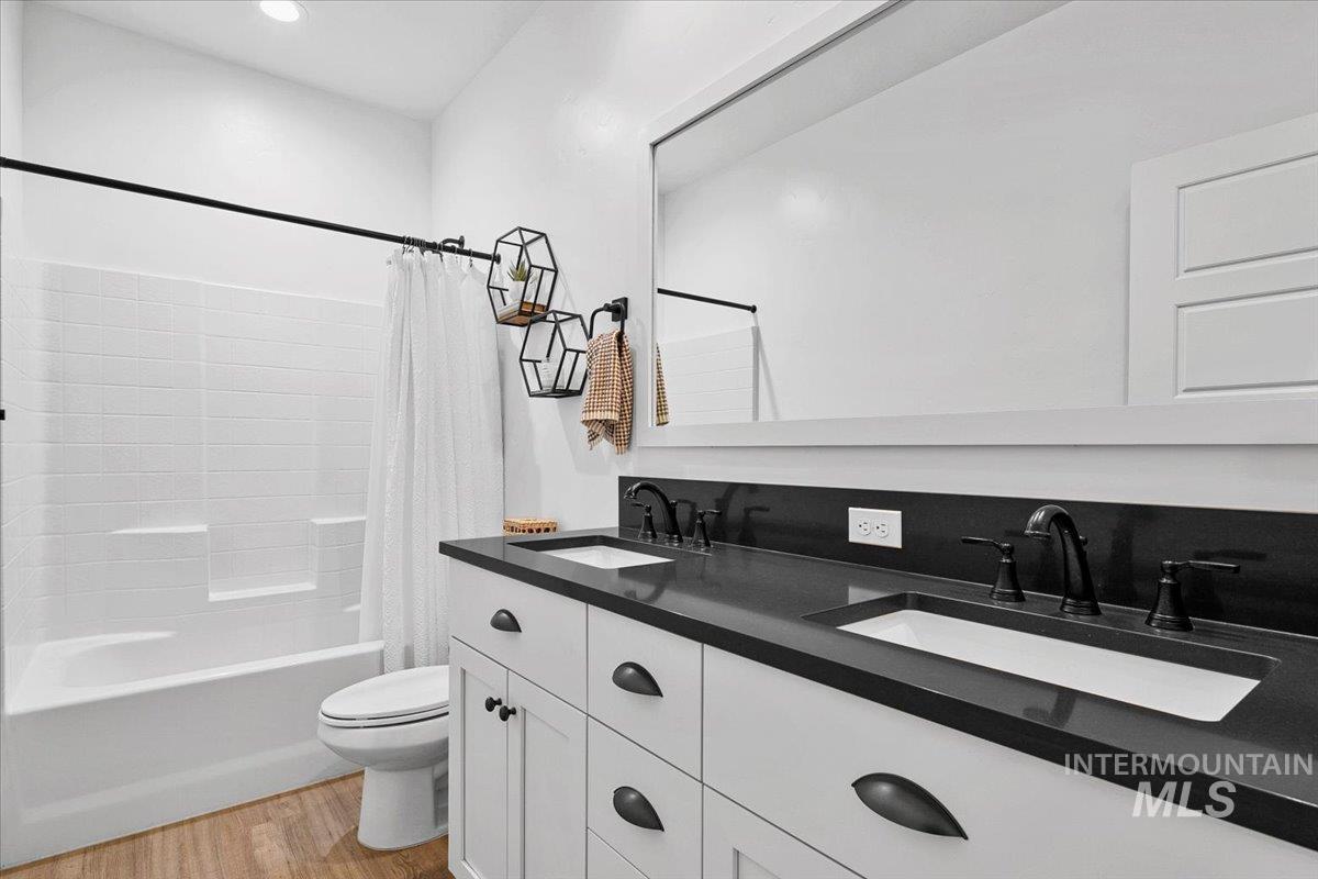 2085 North Concha Court Middleton, ID 83644 - Photo 25 of 37 Full bath featuring double vanity, shower / tub combo with curtain, and light wood finished floors