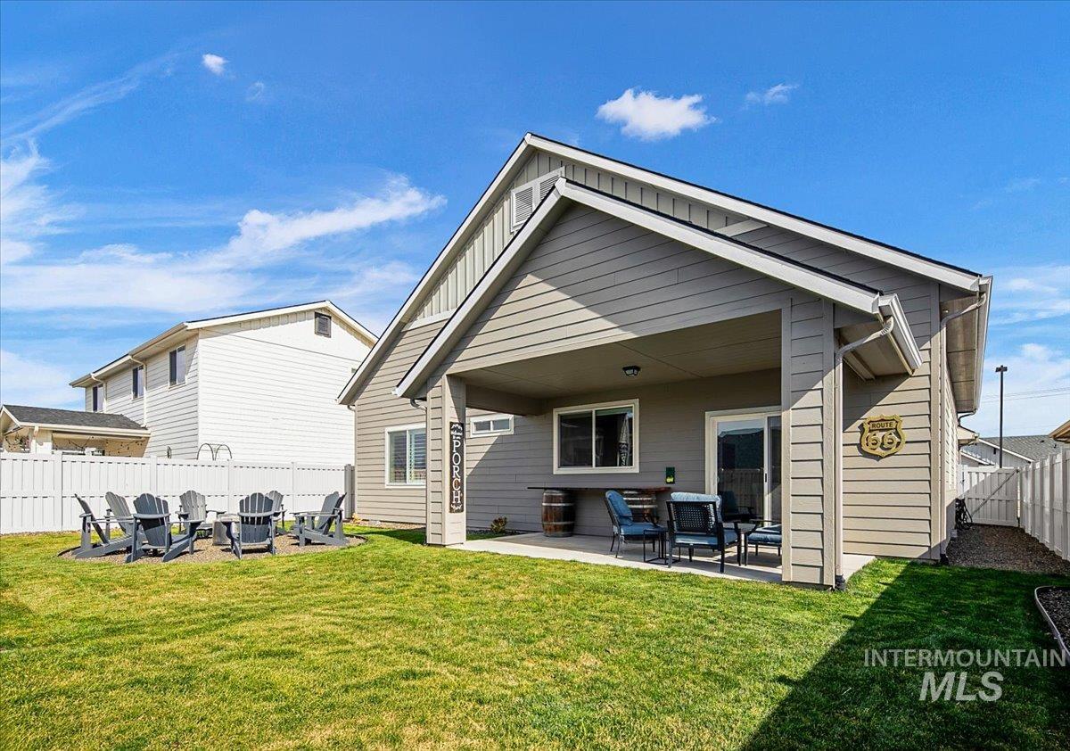 2085 North Concha Court Middleton, ID 83644 - Photo 35 of 37 Rear view of property featuring a patio, a fenced backyard, a fire pit, and board and batten siding