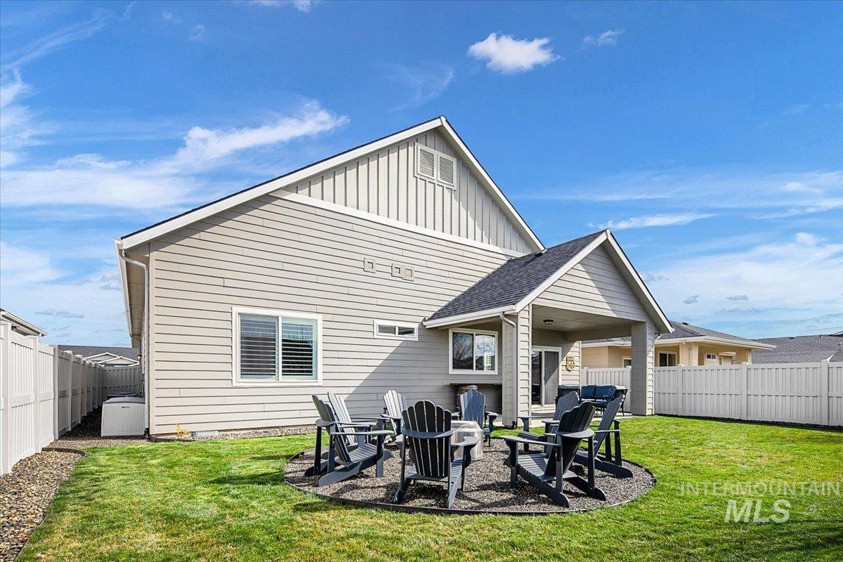 2085 North Concha Court Middleton, ID 83644 - Photo 36 of 37 Rear view of house featuring a fenced backyard, a patio area, board and batten siding, and a fire pit