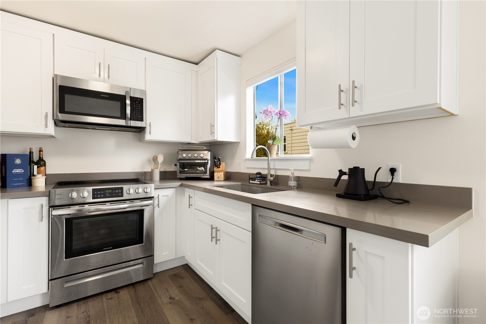 6301 22nd Avenue Northwest Seattle, WA 98107 - Photo 13 of 19 a kitchen with stainless steel appliances granite countertop a sink a stove a microwave and wooden cabinets