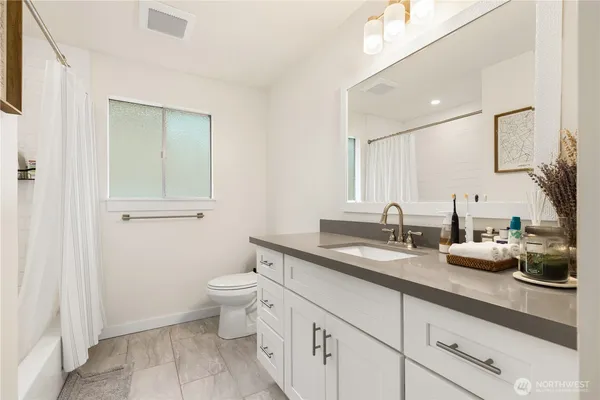 a bathroom with a granite countertop sink a toilet and a mirror