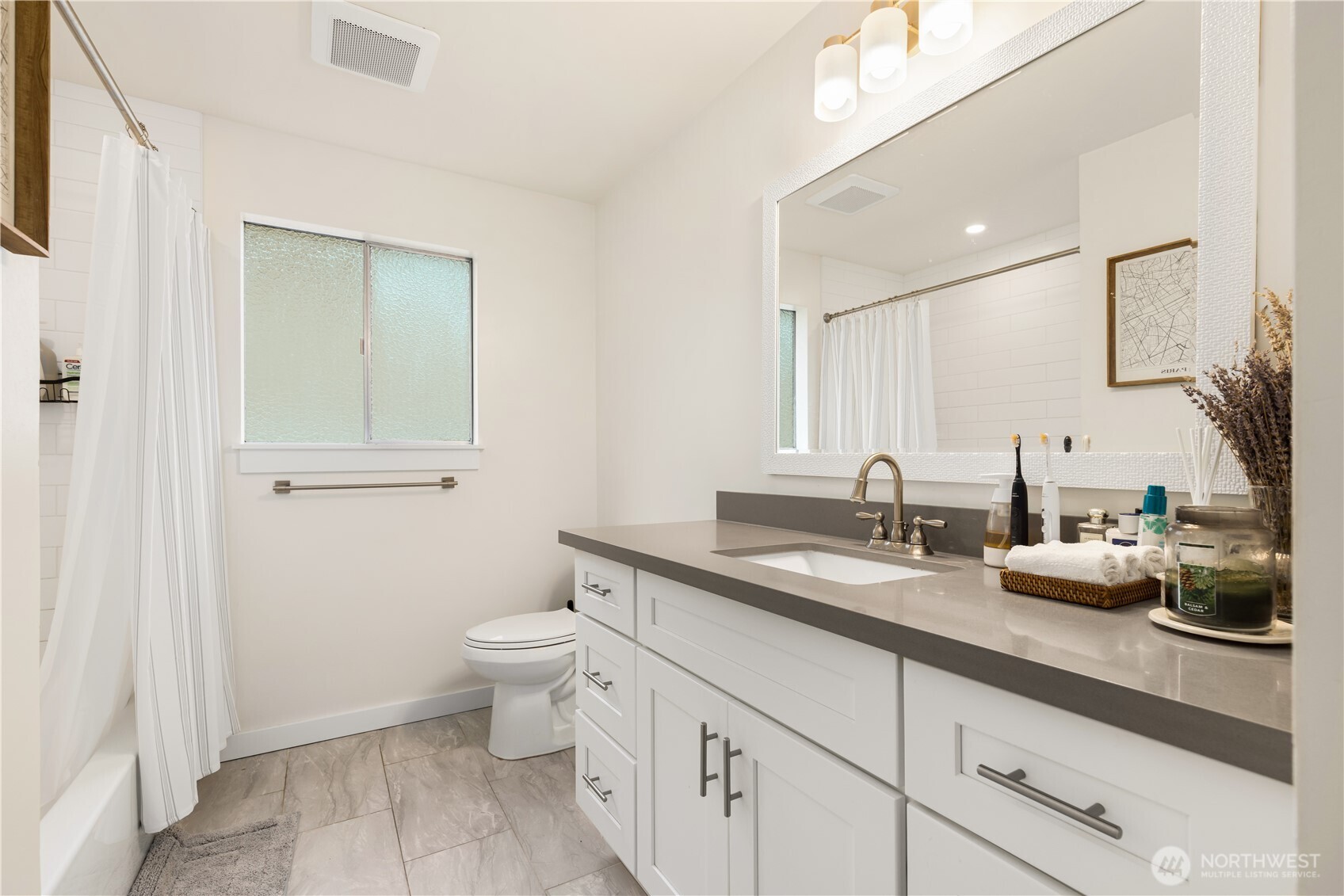 6301 22nd Avenue Northwest Seattle, WA 98107 - Photo 14 of 19 a bathroom with a granite countertop sink a toilet and a mirror