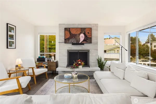 a living room with furniture a fireplace and a large window