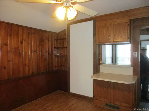 a view of empty room with window and wooden floor