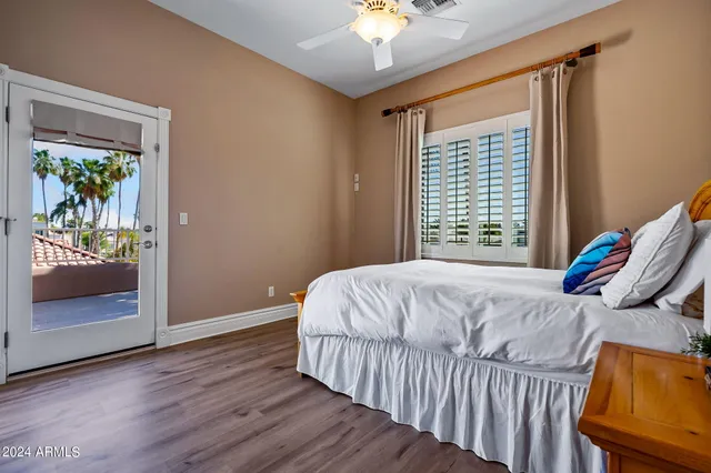 a bedroom with a bed a chandelier and a window