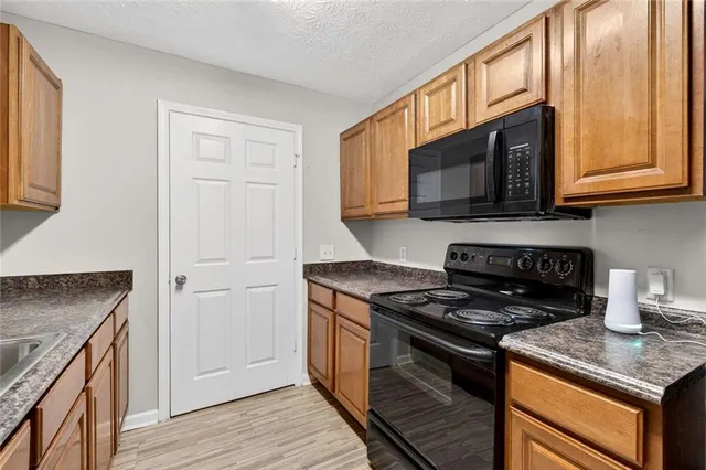 a kitchen with granite countertop stainless steel appliances a sink and a counter space