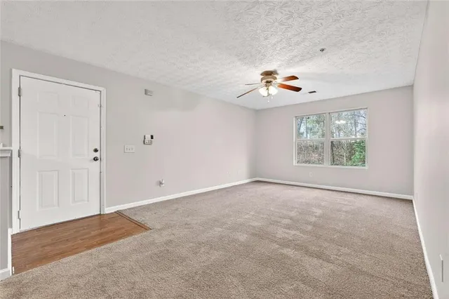 an empty room with chandelier fan