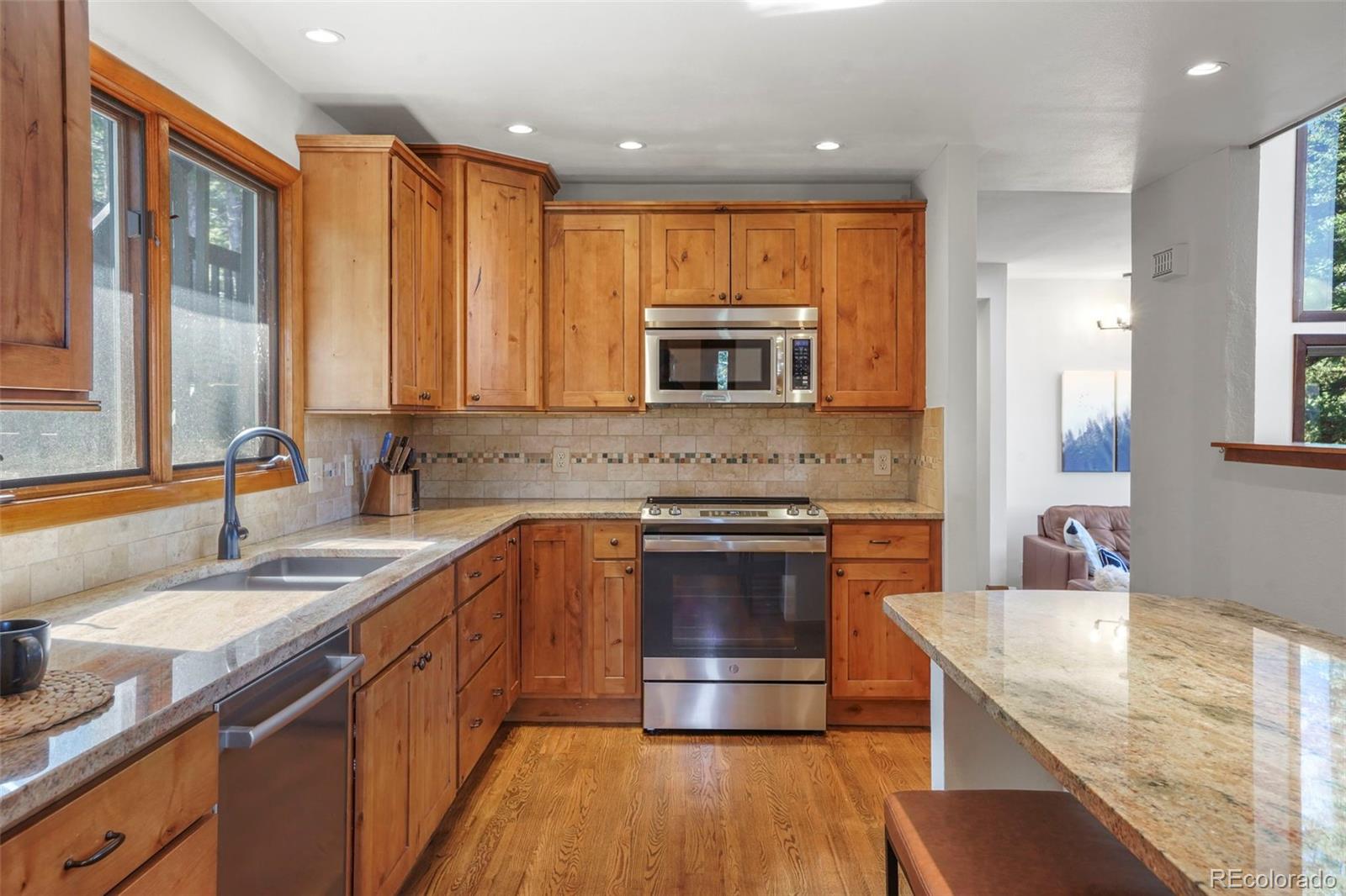 25756 Zugspitz Road Evergreen, CO 80439 - Photo 9 of 43 a kitchen with stainless steel appliances granite countertop a sink stove and microwave