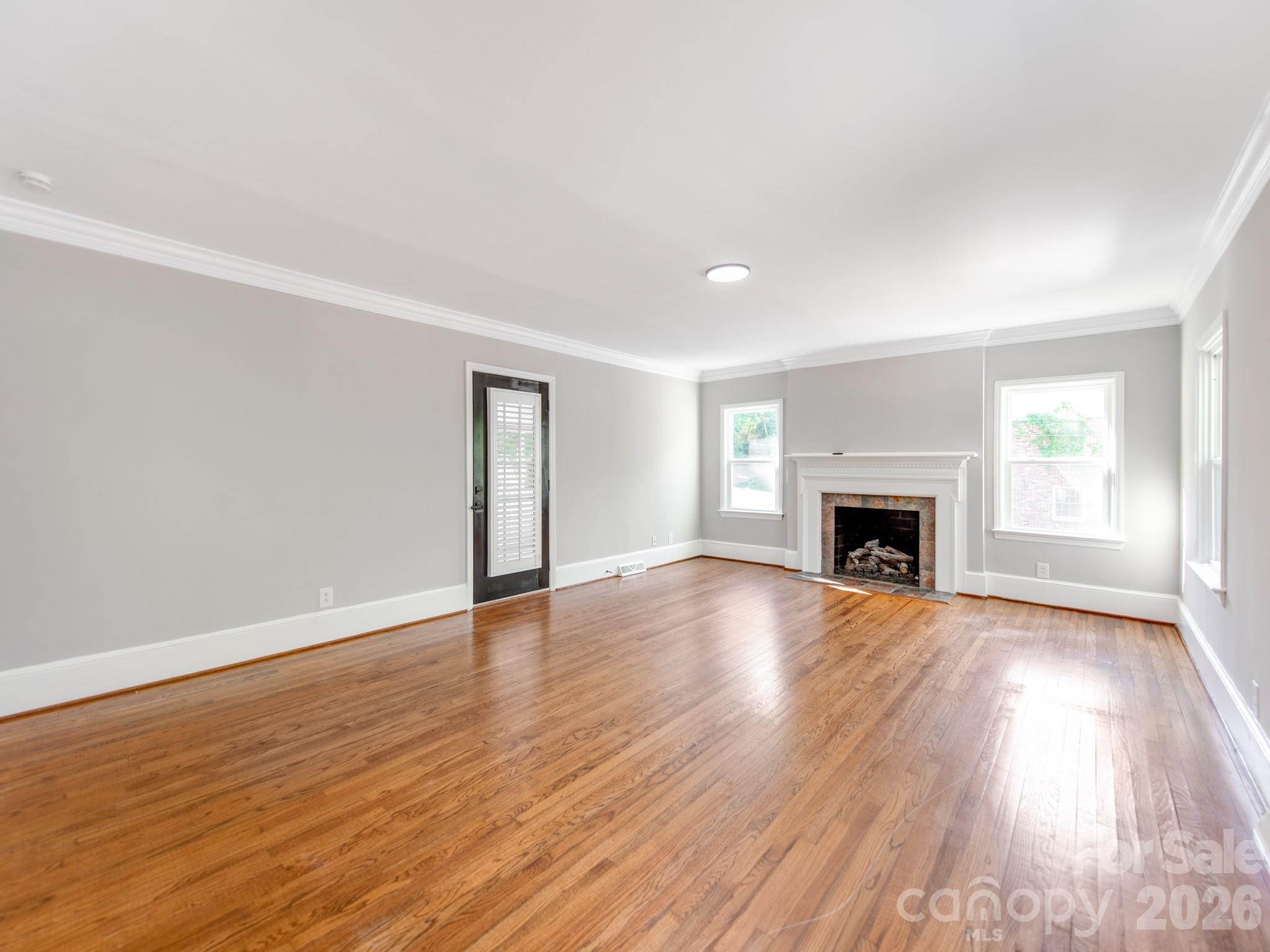 120 Sunset Drive Chester, SC 29706 - Photo 6 of 34 an empty room with wooden floor fireplace and windows