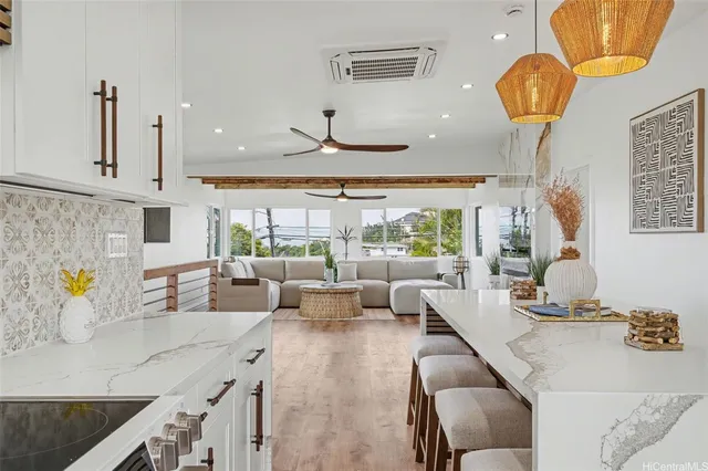 a living room with kitchen island furniture and a chandelier