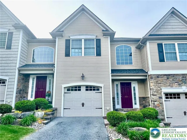 a view of a brick house with large windows and a yard