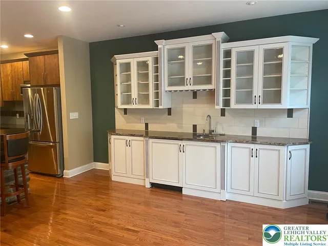 a kitchen with granite countertop a refrigerator sink and cabinets