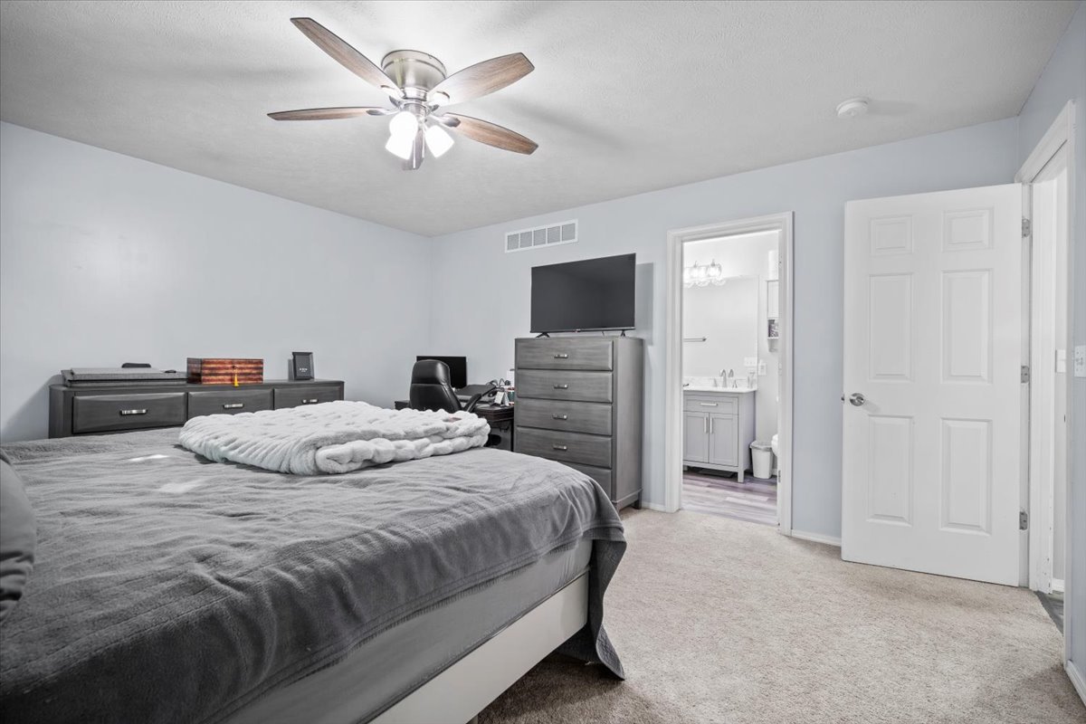1509 Torrey Pines Road Normal, IL 61761 - Photo 15 of 36 a bedroom with a bed a chandelier and a flat screen tv