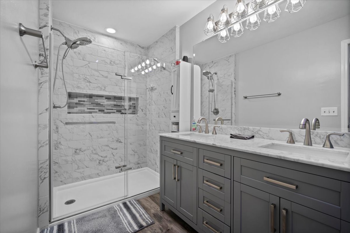 1509 Torrey Pines Road Normal, IL 61761 - Photo 16 of 36 a bathroom with a granite countertop sink a mirror a bathtub and shower