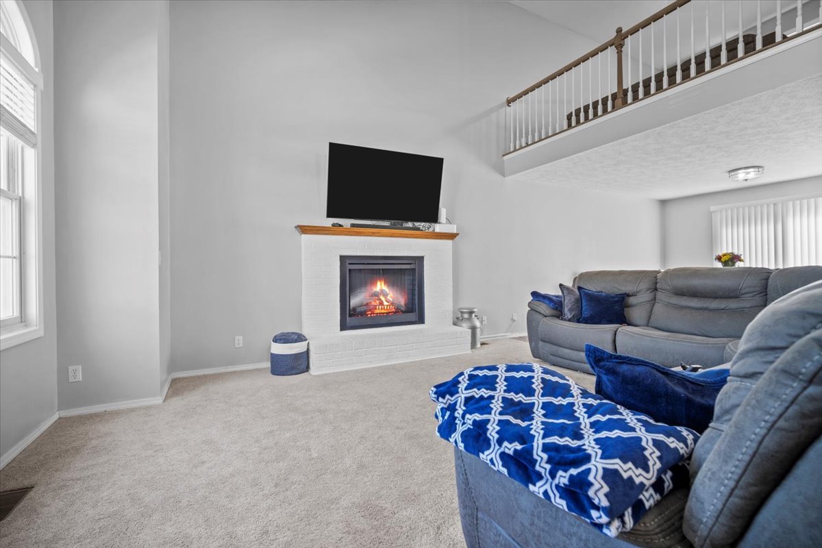 1509 Torrey Pines Road Normal, IL 61761 - Photo 3 of 36 a living room with furniture a flat screen tv and a fireplace