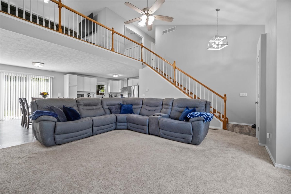 1509 Torrey Pines Road Normal, IL 61761 - Photo 4 of 36 a living room with furniture or stairs and a chandelier