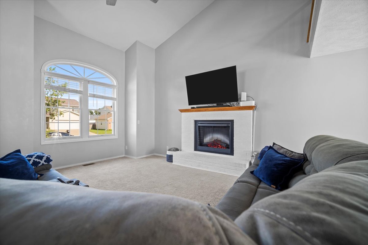 1509 Torrey Pines Road Normal, IL 61761 - Photo 5 of 36 a living room with furniture a flat screen tv and a fireplace