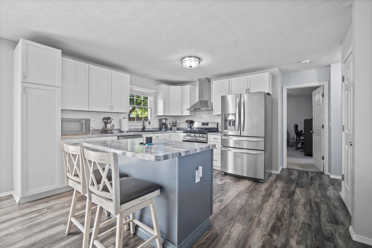 1509 Torrey Pines Road Normal, IL 61761 - Photo 8 of 36 a kitchen with a refrigerator a sink dishwasher a stove and white cabinets with wooden floor