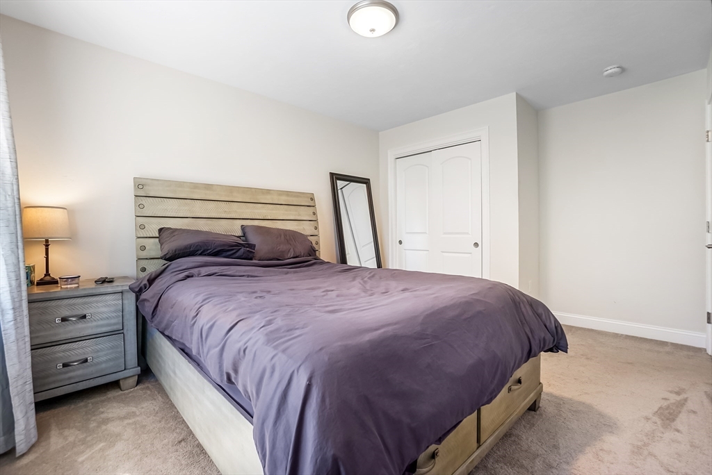 55 Plymouth Street, Unit A5 Whitman, MA 02382 - Photo 15 of 34 a bedroom with a bed and a night stand