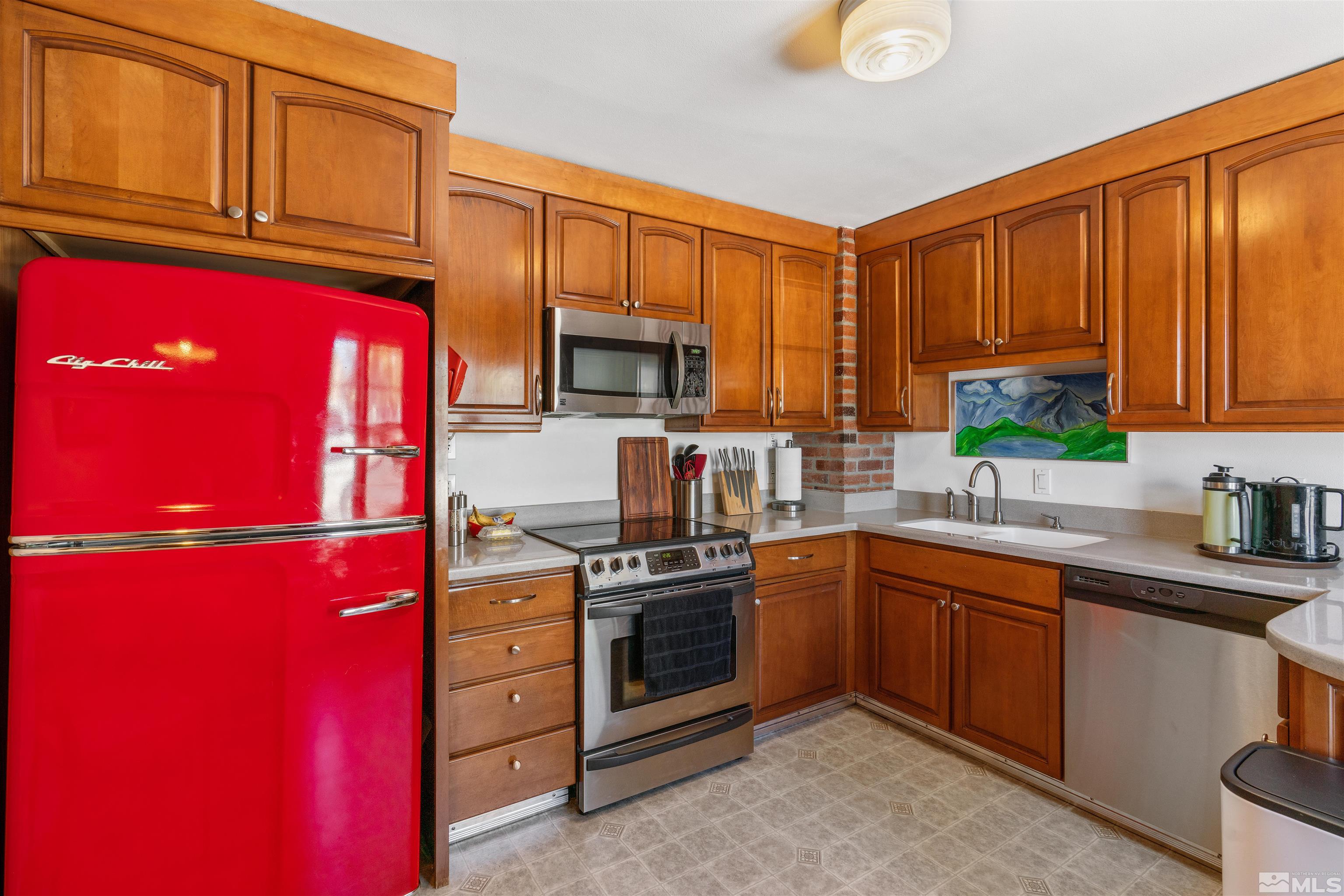 704 Balzar Circle Reno, NV 89502 - Photo 2 of 32 a kitchen with stainless steel appliances granite countertop a stove top oven a sink dishwasher and wooden cabinets