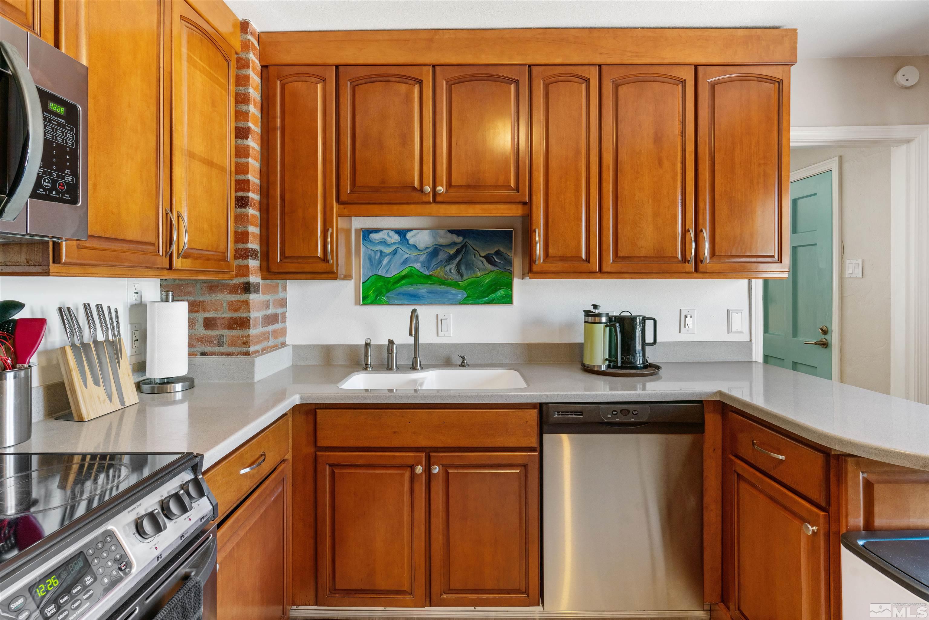 704 Balzar Circle Reno, NV 89502 - Photo 9 of 32 a kitchen with stainless steel appliances granite countertop a sink and dishwasher cabinets with wooden floor