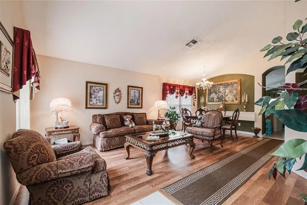 a living room with furniture a lamp and a potted plant