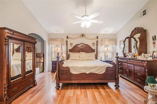 a bedroom with a large bed and a chandelier